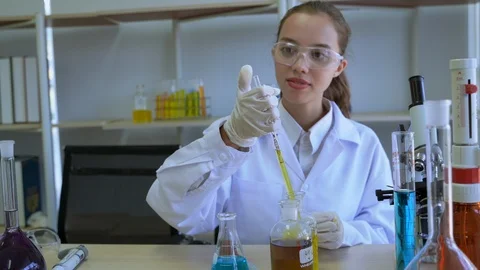 Scientists use pipette to suck liquid and drip onto graduated cylinder Stock Footage 122167987