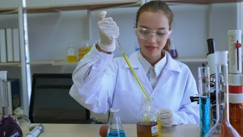 Scientists use pipette to suck liquid and drip onto graduated cylinder Stock Footage 122168197