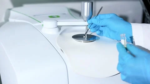 Scientists use stainless spatula to scoop substances into pedestal instrument Stock Footage 321973164