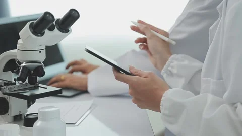 Scientists use technology to analyze data in laboratory setting Stock Footage 325477596