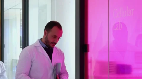 Scientists walking and opening cellular lab door with smartphone Stock Footage 296885038