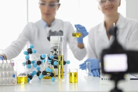 Scientists at work table on which flasks and molecules are filming experiments Stock Photos