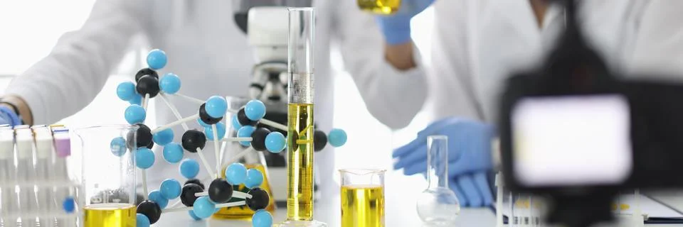 Scientists at work table on which flasks and molecules are filming experiments Stock Photos