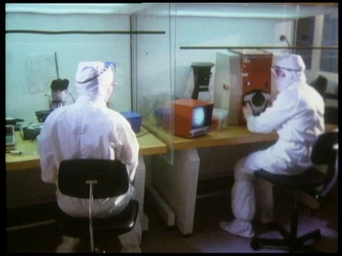 Scientists working in laboratory, using microscopes and talking together, 1985 Stock Footage 136674416