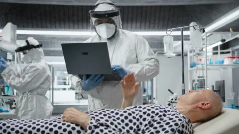 Scientists working in a virology unit with lab testing on infected patient Stock Footage 319213951