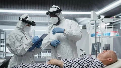 Scientists working in a virology unit with lab testing on infected patient Stock Footage 319367900