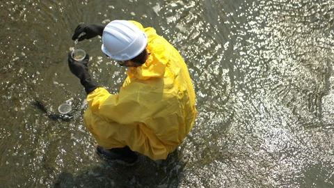 Scientists in yellow protective suits are collecting water samples Stock-Footage 340077732
