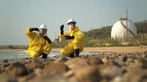 Scientists in yellow suits are collecting water samples from the coastline Stock-Footage 340080132