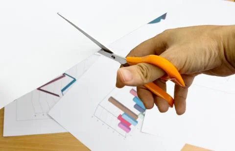 Scissors in the act of paper for do graph and chart for report work Stock Photos