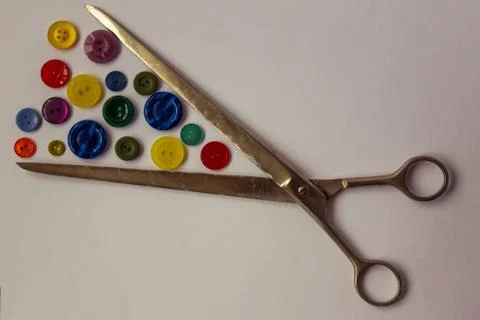 Scissors and colored buttons for clothes. Stock Photos