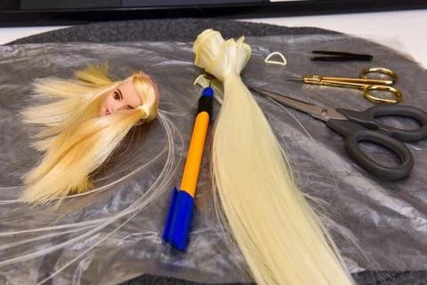 Scissors and homemade tool on the table, how to make hair for a doll, hobby c Stock Photos