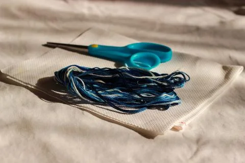 Scissors and multi-colored threads lie on the fabric Stock Photos