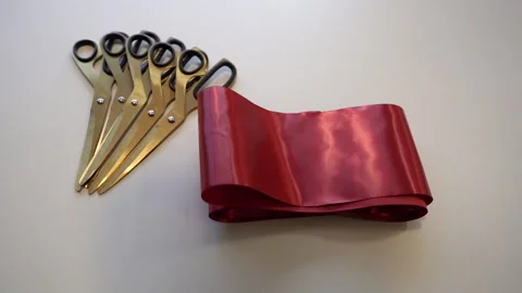 Scissors and a red ribbon are on the table. Stock Footage 307043199