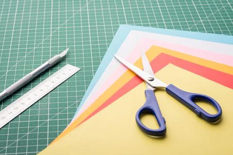 Scissors and stack of coloured papers Stock Photos