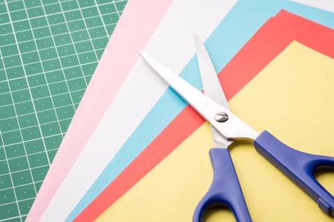 Scissors and stack of coloured papers Stock Photos