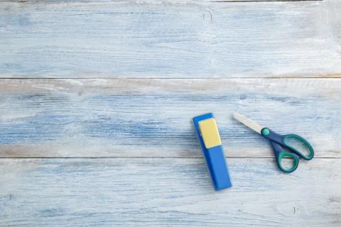 Scissors and stapler on a blue and white shabby vintage wooden background. th Stock Photos