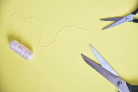 Scissors and thread on yellow background Stock Photos