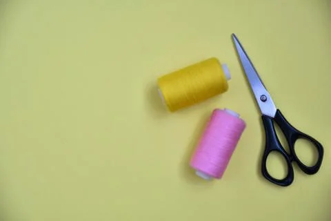 Scissors and thread on yellow background Stock Photos