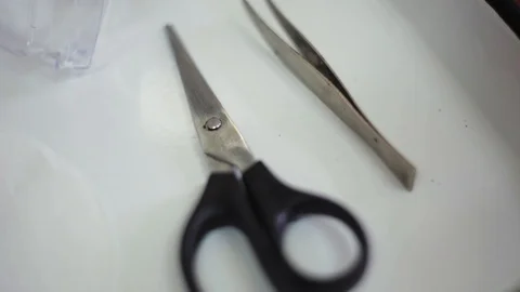 Scissors and tweezers lying on table in laboratory. Instruments for experiment Stock Footage 98552888