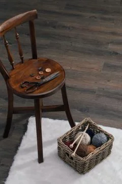 Scissors and yarn ball inside old basket on carpet 库存照片