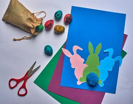 Scissors on blue background easter hares with tail and eggs Stock Photos
