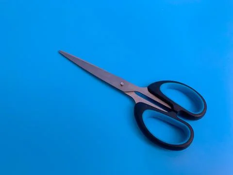 Scissors on a blue background Stock Photos