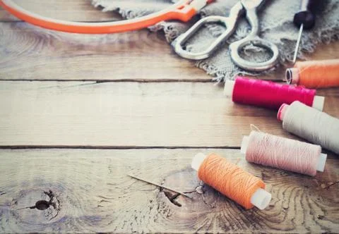 Scissors, bobbins with thread and needles, striped fabric. Old sewing tools o Stock Photos