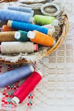 Scissors, bobbins with thread and needles, striped fabric. Old sewing tools Stock Photos