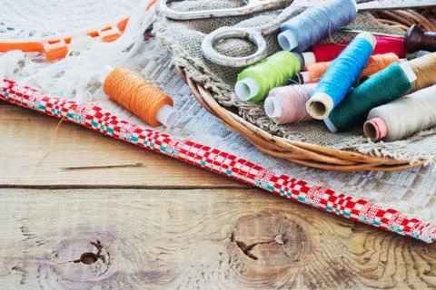 Scissors, bobbins with thread and needles, striped fabric. Old sewing tools Stock Photos