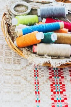 Scissors, bobbins with thread and needles, striped fabric. Old sewing tools Stock Photos