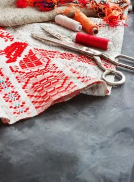 Scissors, bobbins with thread and needles, striped fabric. Old sewing tools o Stock Photos
