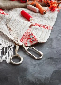 Scissors, bobbins with thread and needles, striped fabric. Old sewing tools o Stock Photos