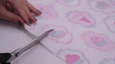 Scissors cut the fabric with a bright and colorful pattern. Close-up. Stock Footage 128882293