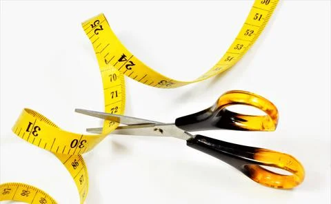 Scissors cut the measuring tape. Stock Photos