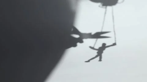 Scissors cut the rope on which the puppet hangs on the shadow Stock Footage 274024351