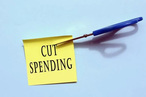 Scissors that cut yellow notepad with text on a blue background. Stock Photos