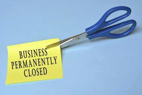Scissors that cut yellow notepad with text on a blue background Stock Photos