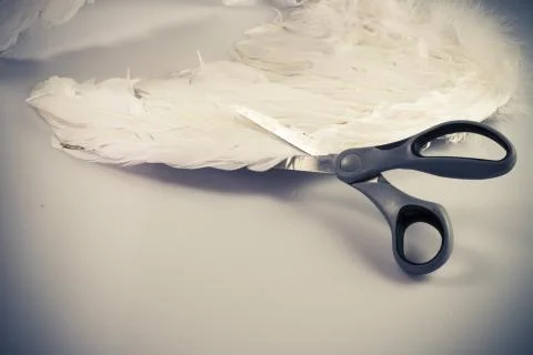 Scissors cutting angel's wing Stock Photos