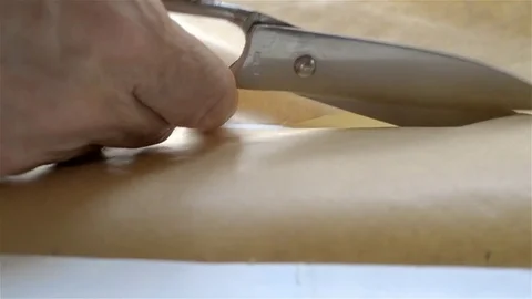 Scissors cutting brown paper Stock Footage