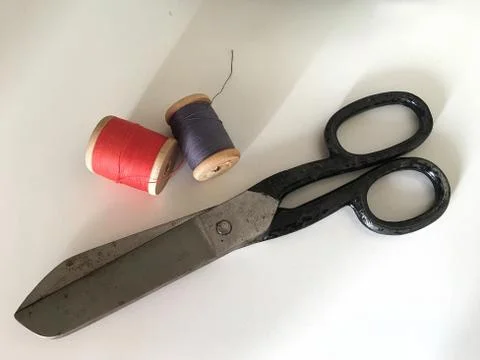Scissors for cutting fabrics and spools with multi-colored threads. Stock Photos
