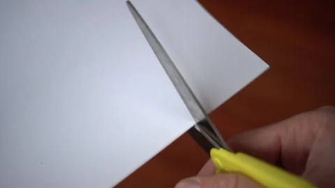 Scissors Cutting a Piece of White Paper, Close Up Stock Footage 102130510