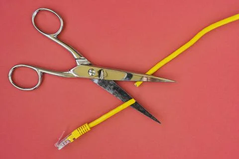 Scissors cutting the yellow network cable Stock Photos