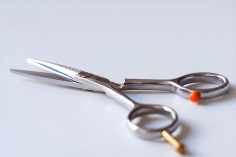 Scissors with finger rest on ring isolated on white background. Stock-Fotos