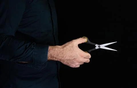 Scissors in hand on black background Stock Photos