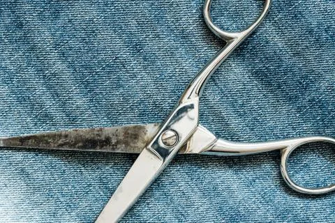 Scissors on the jeans background Stock Photos