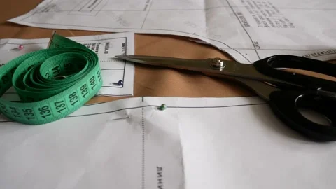Scissors, measuring tape and needle bar on fabric with patterns. Panorama Stock Footage 159211626