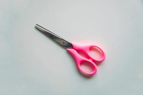 Scissors with pink handle on white background, top view Stock Photos