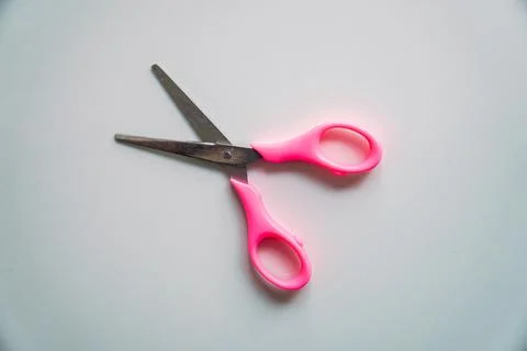 Scissors with pink handle on white background, top view Stock Photos