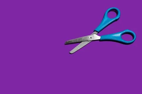 Scissors on a purple background Stock Photos