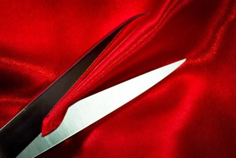 Scissors on red fabric Stock Photos